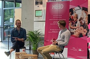 Junger Mann im Gespräch mit einem älteren Mann, bei der Aufzeichnung eines Podcasts.,