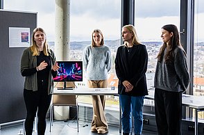 4 Studentinnen präsentieren ihre Ergebnisse zum Motto "Neue Welten". Sie hatten unterschiedliche Welten erstellt, in der es jeweils nur die folgenden Musikrichtungen gibt: Pop, Rock, Klassik, Techno, Indie, Country und Reggae. Diese Unterscheiden sich in Opik, Architektur und menschlichem Verhalten. 