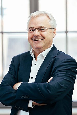 Rald Offe (älterer Herr mit weißem Haar) lächelt freundlich in die Kamera